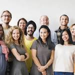 Diverse group of people stand together smiling
