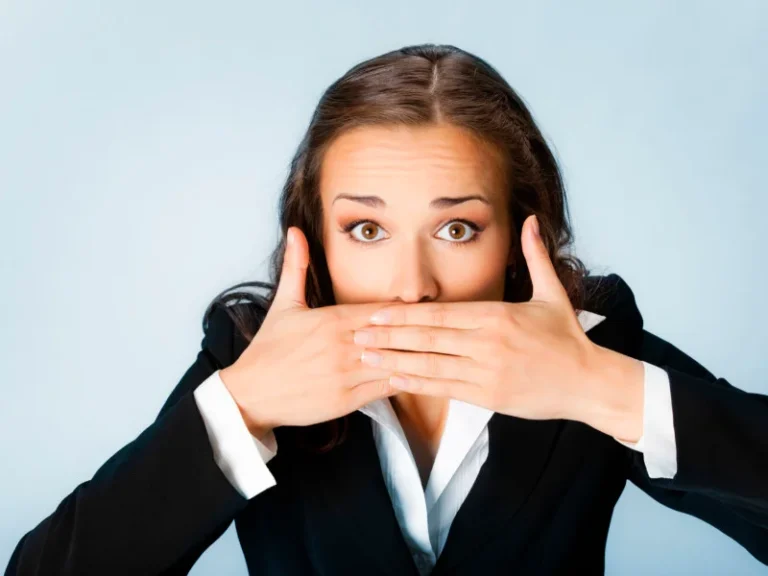 woman with raised eyebrows covers her mouth with both hands